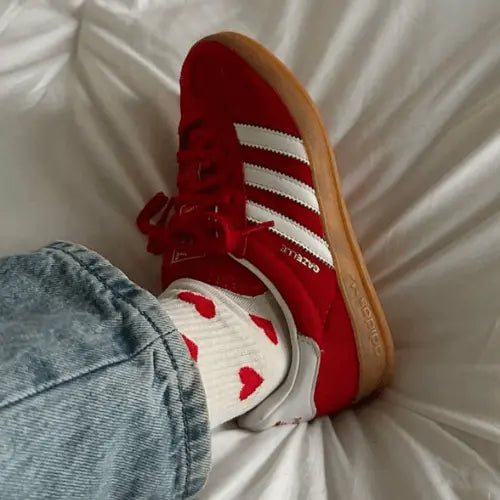 La Adidas Gazelle Indoor Scarlet Cloud White  porté avec un jean bleu clair et des chaussettes blanches à cœur rouge.