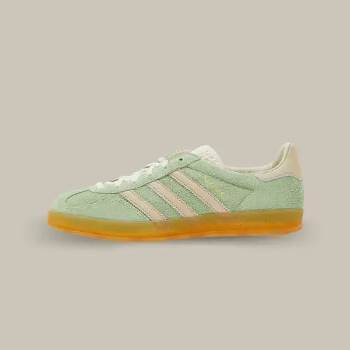 La Adidas Gazelle Indoor Semi Green Spark de côté avec son coloris vert pâle et ses trois bandes en cuir jaune pâle accordées au heel tab et à la languette.