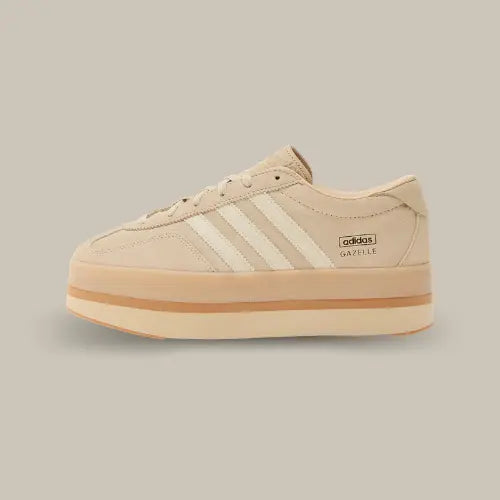 La Adidas Gazelle Stack Sand Strata vue de côté avec sa base en daim beige et ses trois bandes blanches. On retrouve une plateforme XXL séparé par une bande marron.