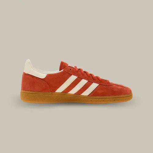 La Adidas Handball Spezial Aged Red de côté avec sa couleur rouge vielli et ses trois bandes en cuir blanc cassé accordées au heel tab et au branding de la languette.