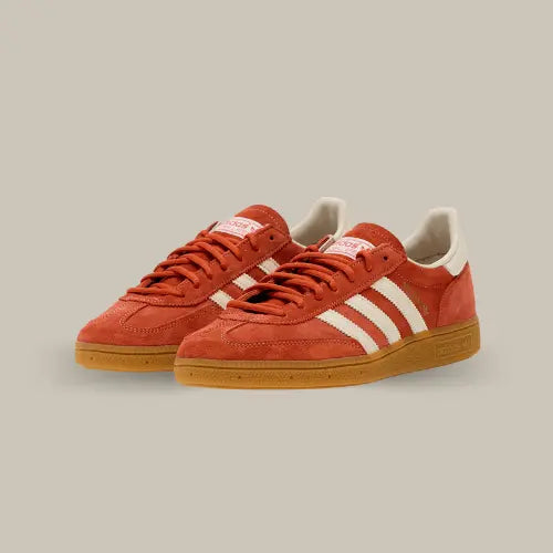 La Adidas Handball Spezial Aged Red possède une tige en nubuck rouge vieilli, lui donnant un aspect usé et authentique, avec ses trois bandes en cuir blanc cassé accordées au heel tab et au branding de la languette. On retrouve le branding de couleur doré sur les côtés et la semelle en gomme qui finalise cette magnifique paire