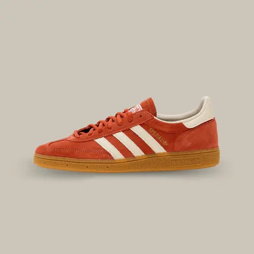 La Adidas Handball Spezial Aged Red de côté avec sa couleur rouge vielli et ses trois bandes en cuir blanc cassé accordées au heel tab et au branding de la languette.