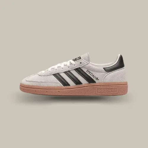 La Adidas Handball Spezial Aluminum Core Black vue de coté avec sa tige en nubuck gris, ses trois bandes en cuir noir et sa semelle en gomme.