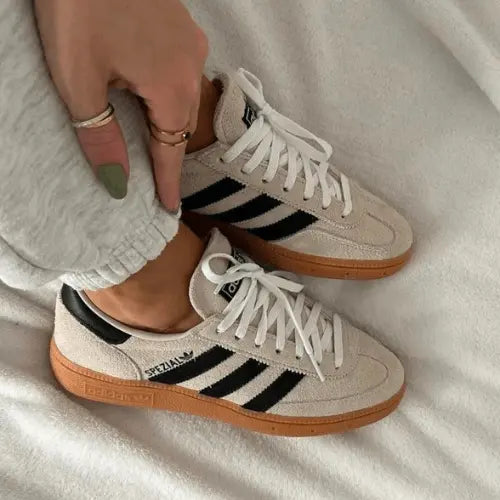 La Adidas Handball Spezial Aluminum Core Black portée avec un jogging gris.