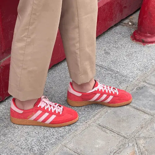 La Adidas Handball Spezial Bright Red Clear Pink porté avec un pantalon marron.