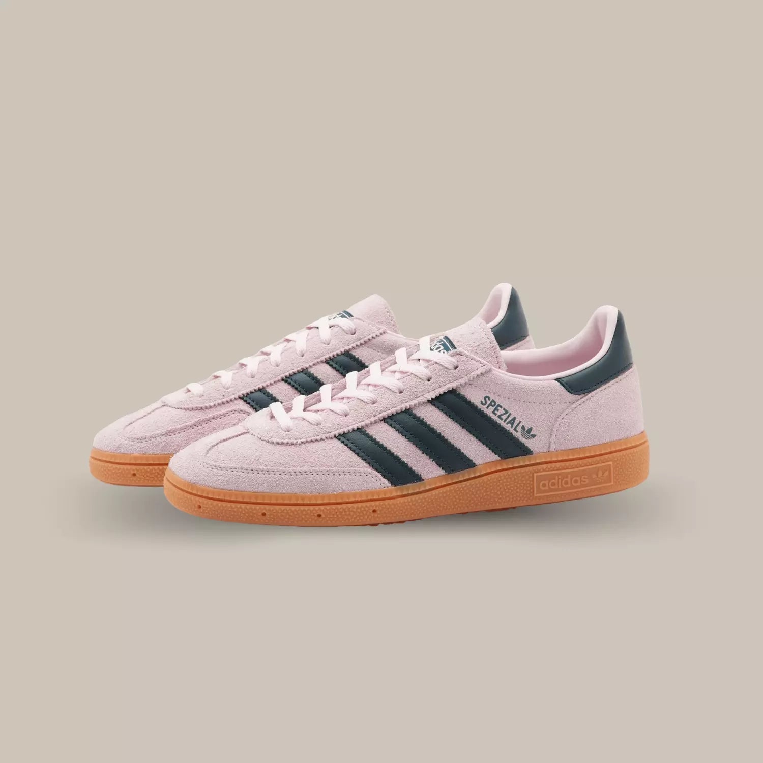 La tige en suède de haute qualité de la Adidas Handball Spezial Clear Pink arbore une teinte rose claire qui rappelle l'esthétique rétro. Les trois bandes emblématiques d'Adidas en cuir noir ornent les côtés, ajoutant une touche classique à la chaussure.