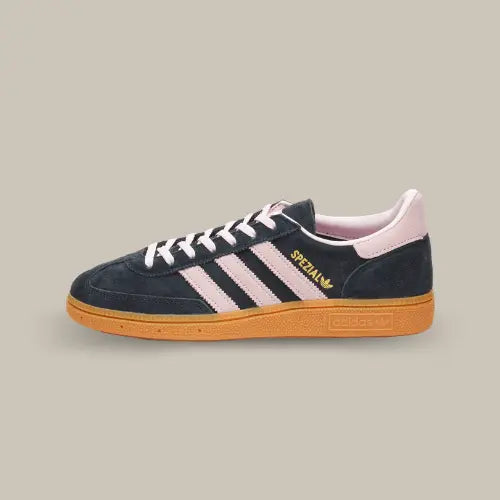 La Adidas Handball Spezial Core Black Clear Pink Gum de couleur noire avec les trois bandes aidas rose accordées au heel tab, aux lacets et au branding. On retrouve le logo "Spezial" en or et la semelle en gomme.