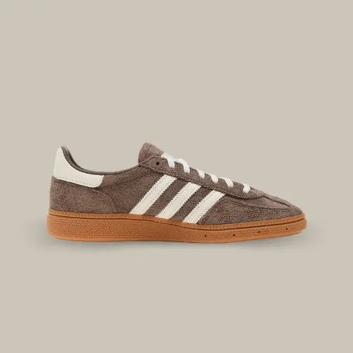 La Adidas Handball Spezial Earth Strata de coté avec son coloris marron et ses trois bandes blanches assorties aux lacets et au heel tab.