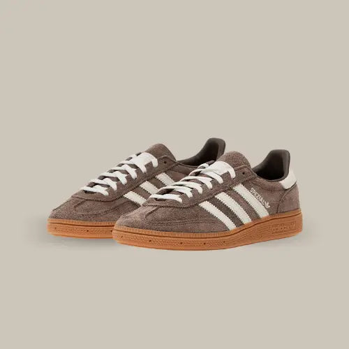La Adidas Handball Spezial Earth Strata avec son coloris marron, ses trois bandes blanches assorites aux lacets et au heel tab et sa semelle en gomme marron.