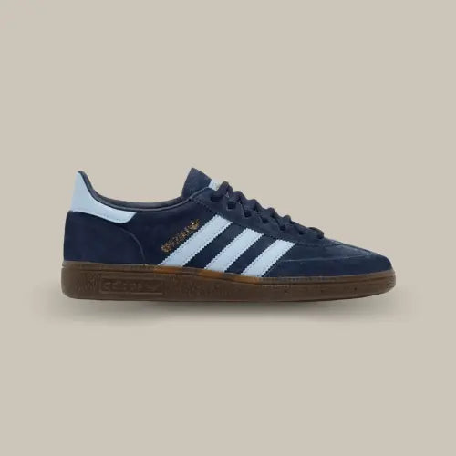 La Adidas Handball Spezial Navy Gum de coté avec sa tige en suède bleu profond, ses trois bandes bleu ciel et sa gomme en caoutchouc.