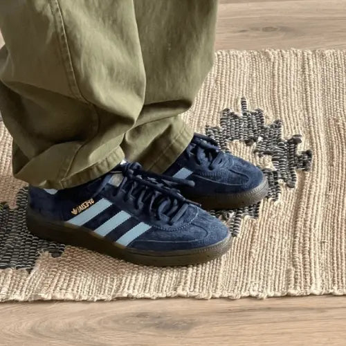 La Adidas Handball Spezial Navy Gum porté avec un jean large vert.