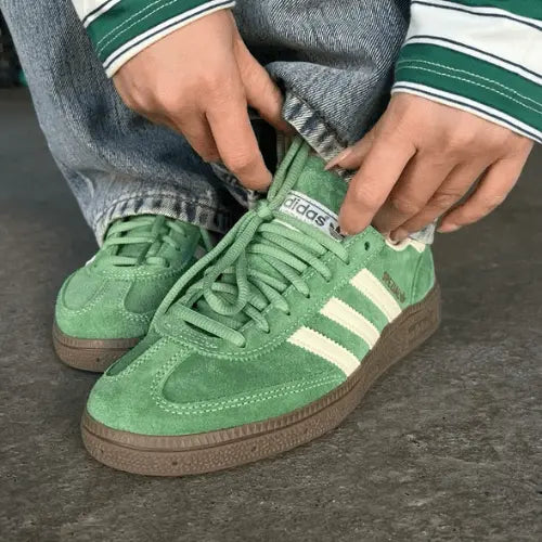 LaAdidas Handball Spezial Preloved Green White porté avec un jean gris clair avec un pull assorti.