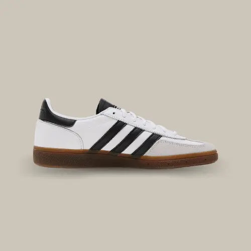 La Adidas Handball Spezial White Black Gum de côté avec sa base en cuir blanc et ses trois bandes en cuir noir accordées au heel tab et à la languette.