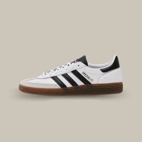 La Adidas Handball Spezial White Black Gum de côté avec sa base en cuir blanc et ses trois bandes en cuir noir accordées au heel tab et à la languette.