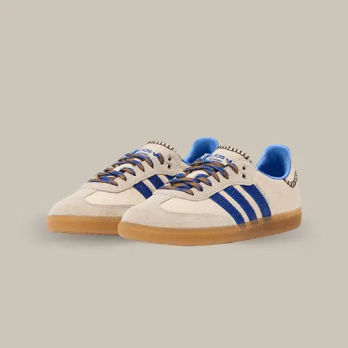 La Adidas Samba Nylon Wales Bonner Wonder Clay Royal possède une base en cuir blanc cassé avec des empiècement en daim ton sur ton au niveau du mudguard et des lacets. On retrouve les trois bandes de couleur et un heel tab accordé à la tige comportant des détails brodés à l'image des créations de Grace Wales Bonner.