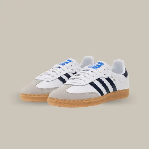 La Adidas Samba OG Cloud White Night Indigo Gum possède une base en cuir blanc avec un mudguard en suède gris et les bandes en cuir bleu nuit accordées au heel tab. On retrouve la célèbre semelle en gomme caractéristique du modèle de la marque allemande.
