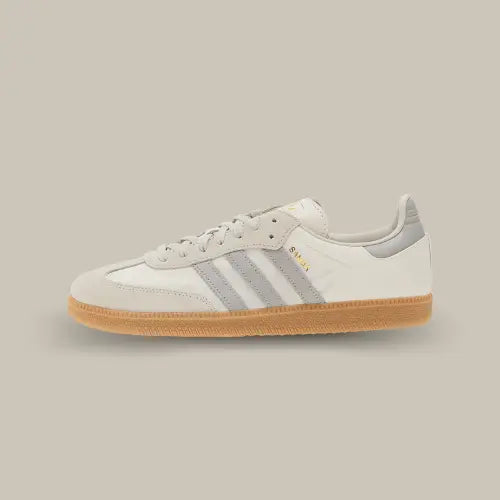 La Adidas Samba OG "OFF-WHITE GREY TWO" avec sa base en cuir blanc, ses trois bandes grises assorties au heel tab et ses empiécemens en suède gris clair au niveau de la toebox et des lacets.