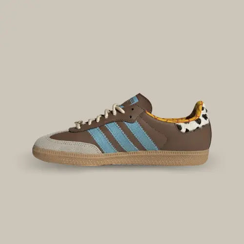 La Adidas Samba OG Toy Story Woody vue de côté avec sa base en cuir marron, ses trois bandes bleu, son heel tab en vache et son intérieur de couleur jaune.