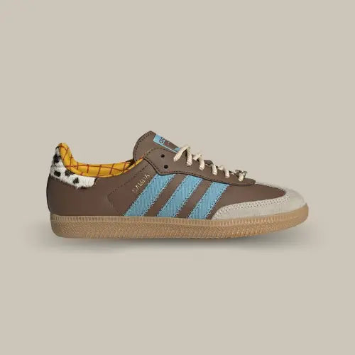 La Adidas Samba OG Toy Story Woody vue de côté avec sa base en cuir marron, ses trois bandes bleu, son heel tab en vache et son intérieur de couleur jaune.