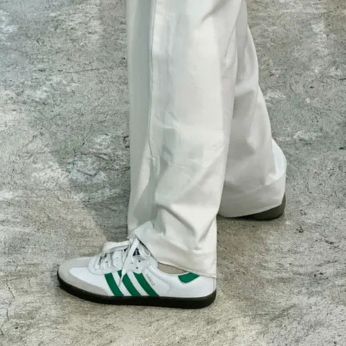La Adidas Samba OG White Green porté avec un pantalon blanc.