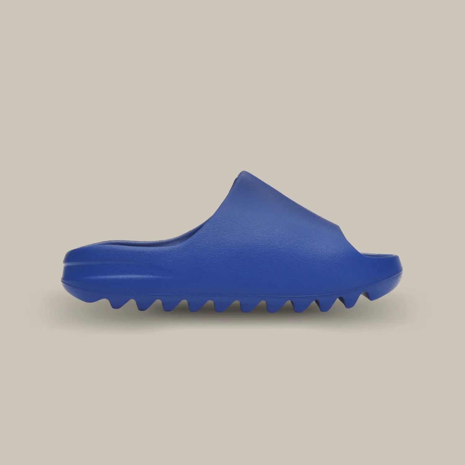 La Yeezy Slide Azure de coté, cette claquette avec son coloris monochrome bleu roi et sa structure en mousse EVA.