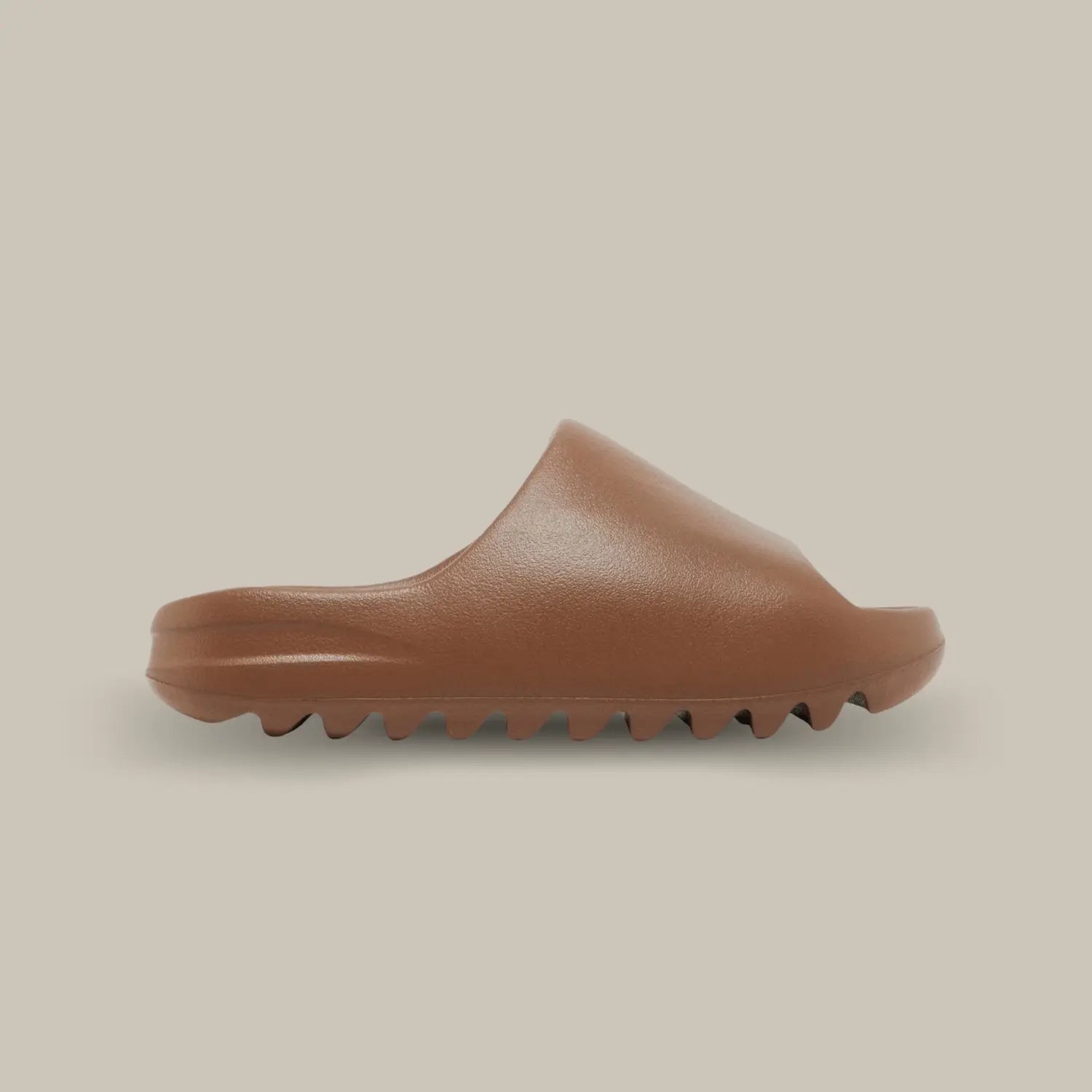 La Adidas Yeezy Slide Flax arrive avec son coloris marron chocolat. Elle possède sa célèbre mousse EVA pour un confort sans pareil. On retrouve également son aspect monobloc avec une outsole dentelée.
