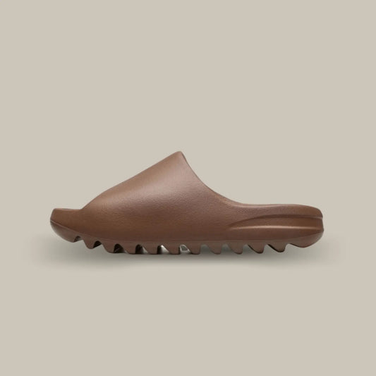 La Adidas Yeezy Slide Flax de coté, cette claquette avec son coloris monochrome marron chocolat et sa structure en mousse EVA.