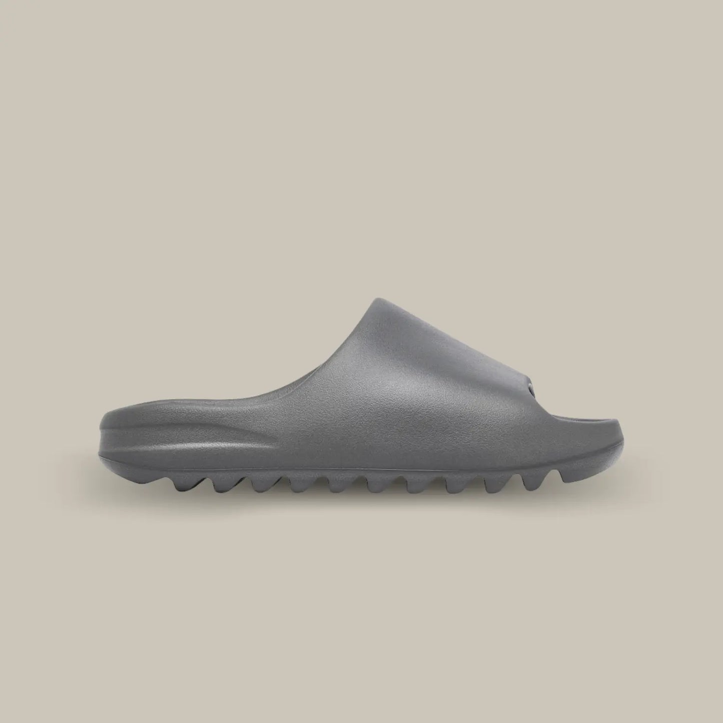 La Yeezy Slide « Granite » de coté, cette claquette avec son coloris monochrome gris et sa structure en mousse EVA.