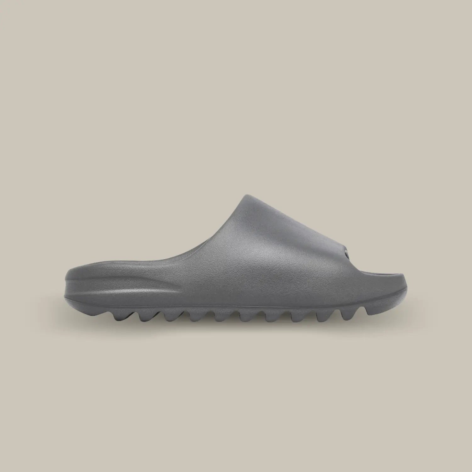 La Yeezy Slide « Granite » de coté, cette claquette avec son coloris monochrome gris et sa structure en mousse EVA.