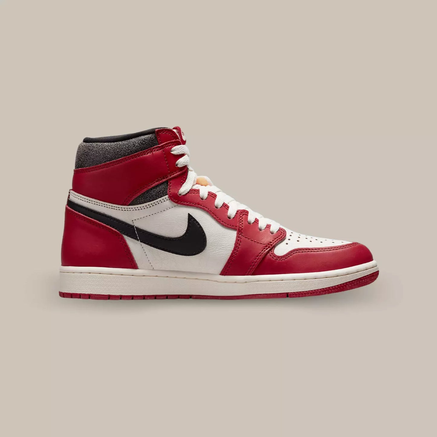 La Air Jordan 1 High Chicago Lost And Found de coté avec une base en cuir blanc à la finition craquelée que l’on retrouve également sur le col en cuir noir et superpositions en cuir rouge.