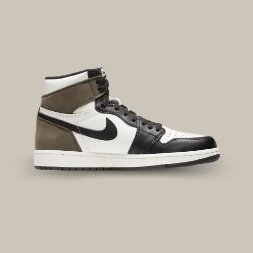 La Air Jordan 1 High Dark Mocha de coté avec sa base en cuir blanc et ses empiècement en cuir noir et suède marron au niveau du talon.