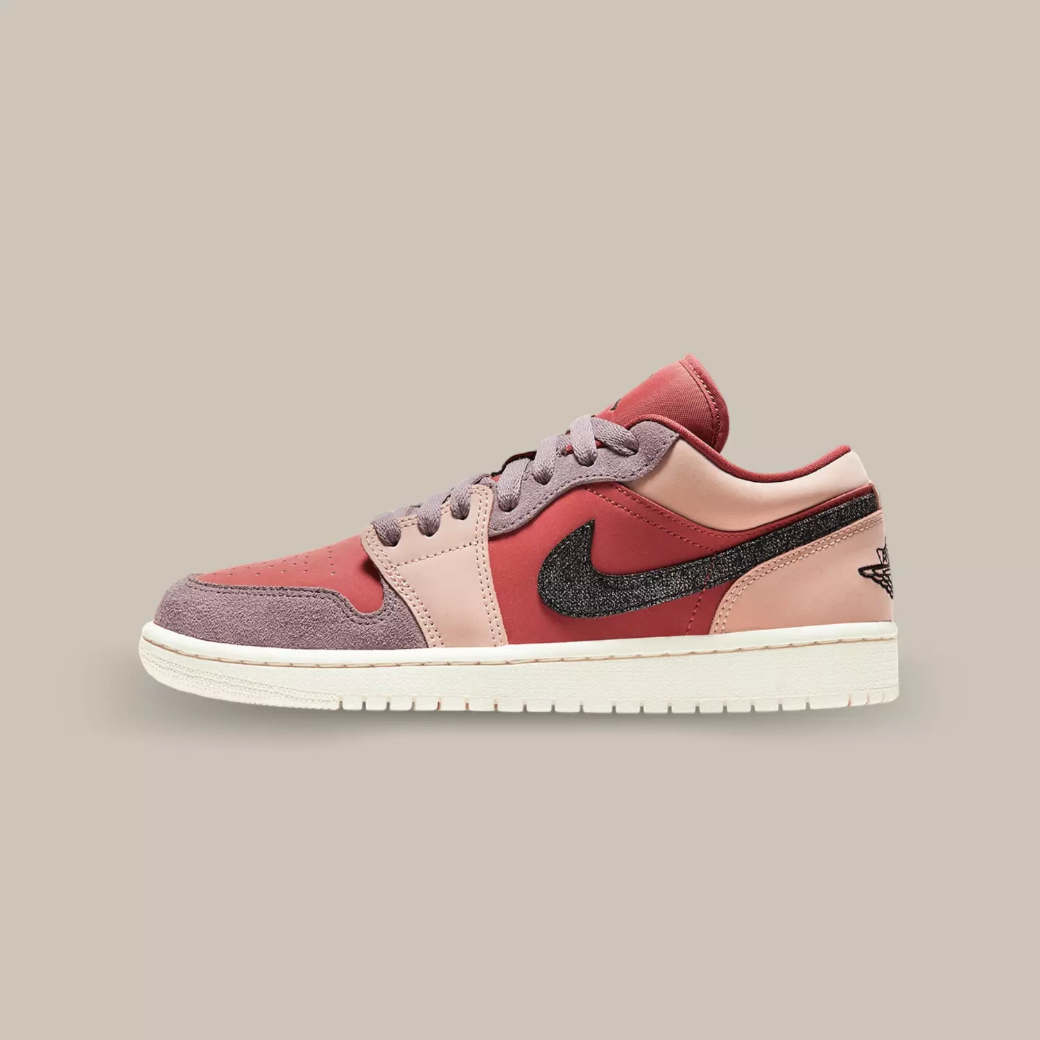 La Jordan 1 Low Canyon Rust de coté  composé d’empiècements en cuir et en suède de plusieurs couleurs, rose pale, rouge et mauve.