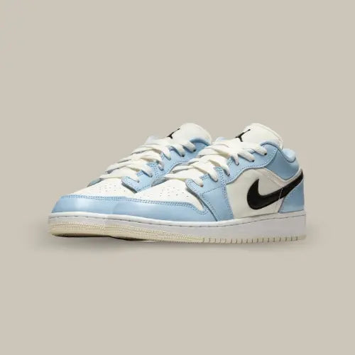 La Air Jordan 1 Low Ice Blue Black possède une base en cuir crème qui s'accorde à la languette et aux lacets. On retrouve des superpositions en cuir bleu ciel qui contrastent au swoosh noir. Une semelle blanche à l'outsole beige vient parfaire cette magnifique paire.