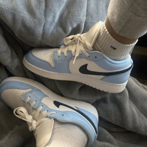 La Air Jordan 1 Low Ice Blue Black portée avec un jogging gris.