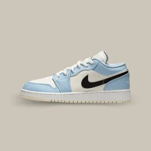 La Air Jordan 1 Low Ice Blue Black de côté avec son coloris bleu et blanc qui contraste avec le swoosh noir.