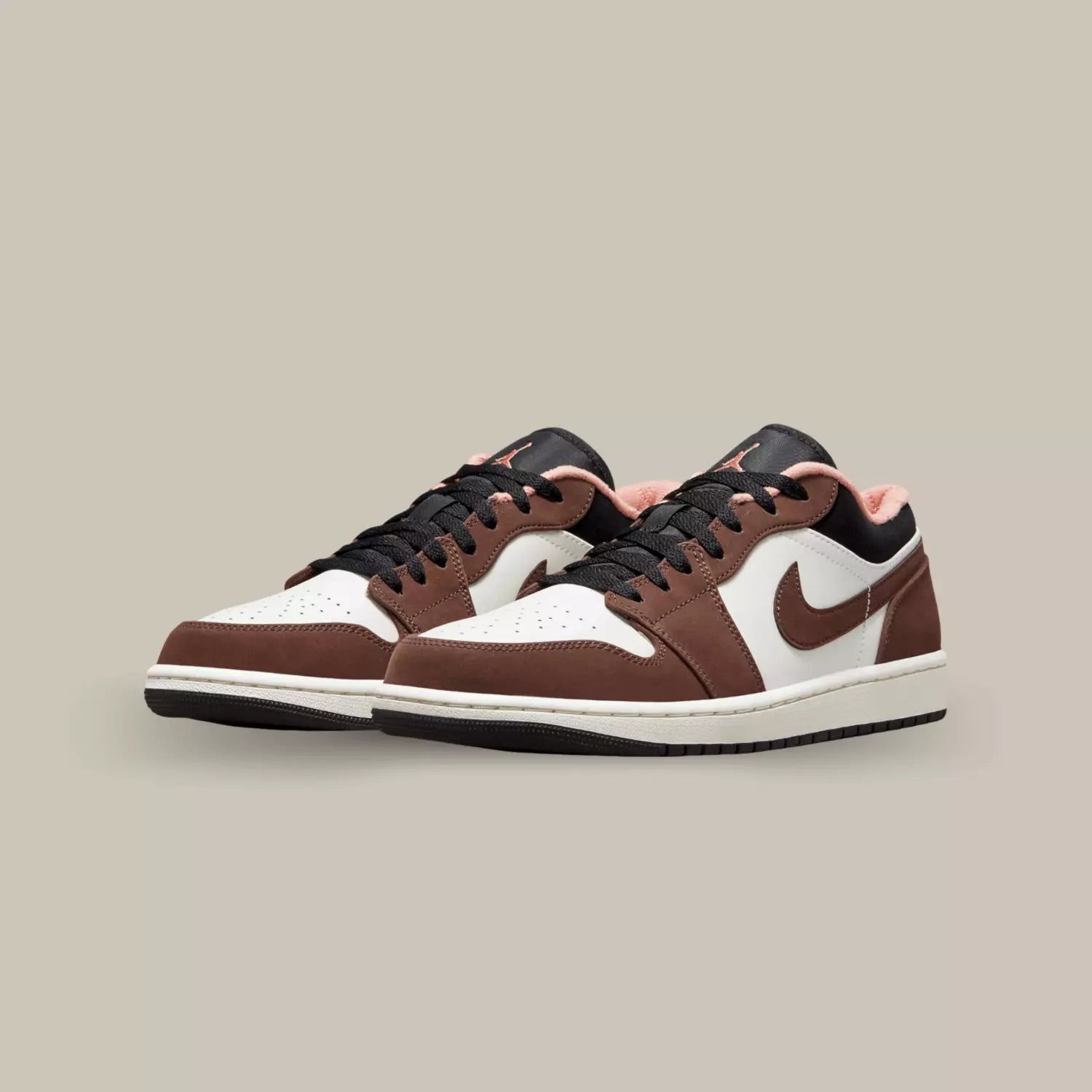 La Air Jordan 1 Low Mocha se pare d’une base en cuir blanc cassé, accompagnée de superpositions en cuir synthétique marron. On retrouve un col rose crimson qui donne une petite touche de fantaisie à la paire.
