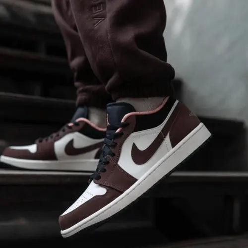 La Air Jordan 1 Low Mocha présenté avec un jogging marron foncé.