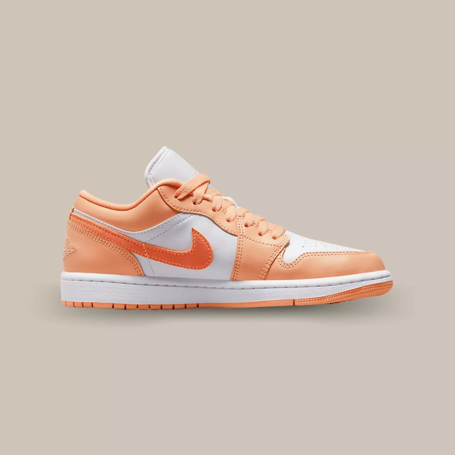 La Jordan 1 Low Washed Denim de coté avec sa base de couleur blanche et ses empiècements en cuir pêche.