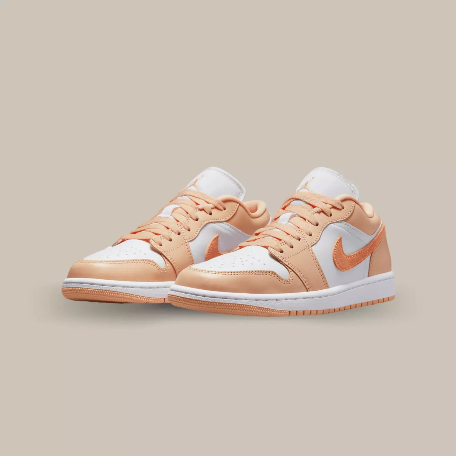 Cette Jordan 1 Low Sunset Haze propose une base en cuir blanc avec des empiècements en cuir pêche. On retrouve un swoosh en suède orange sur les cotés.