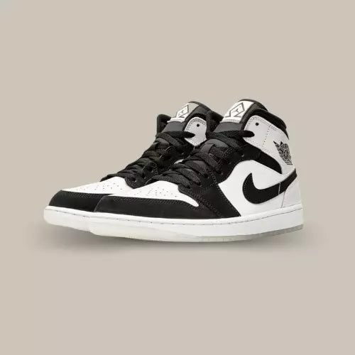 La Air Jordan 1 Mid Diamond Shorts présente une base en cuir blanc qui se voit recouverte d’empiècements en daim noir et reprend le color-block emblématique de la Black Toe.
