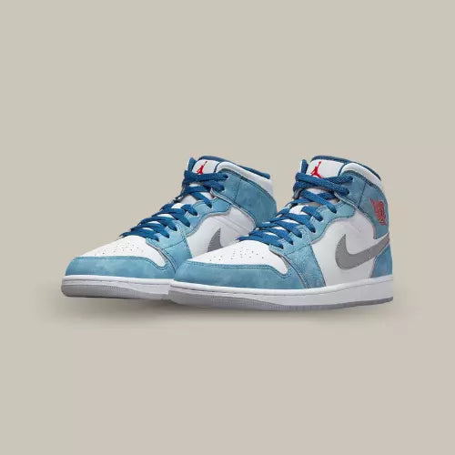 La Air Jordan 1 Mid French Blue Fire Red présente une base en cuir blanc surmontée d’empiècements en suède bleu clair. Beaucoup de ressemblance avec la Air Jordan 1 OG Hyper Royal, la différence réside dans le fait que nous sommes cette fois ci dans une version Mid.