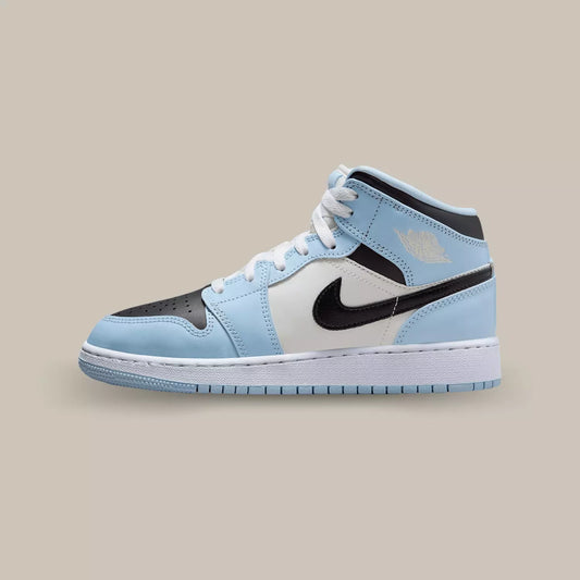 La Air Jordan 1 Mid Ice Blue de coté avec sa tige en cuir blanc et ses superpositions en cuir bleu ciel.