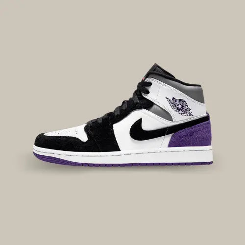 La  Air Jordan 1 Mid SE Purple vue de côté avec son cuir blanc, son mudguard en daim noir et son talon en daim violet.