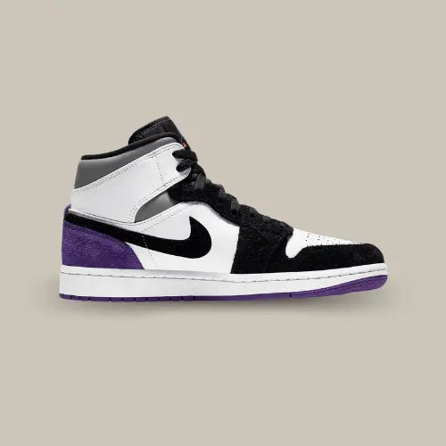 La  Air Jordan 1 Mid SE Purple vue de côté avec son cuir blanc, son mudguard en daim noir et son talon en daim violet.