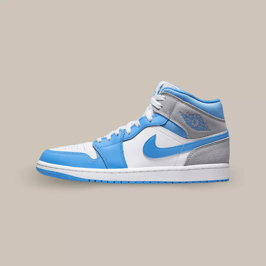 La Air Jordan 1 Mid University Blue Grey de coté avec son coloris UNC et une touche de suède gris qu’on retrouve à l’arrière de la sneakers.