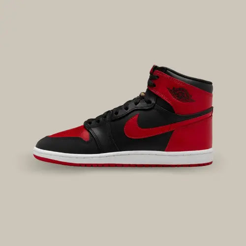 La Air Jordan 1 Retro High '85 OG Bred (2025) vue de côté avec sa base en cuir noir et rouge et sa midsole blanche.