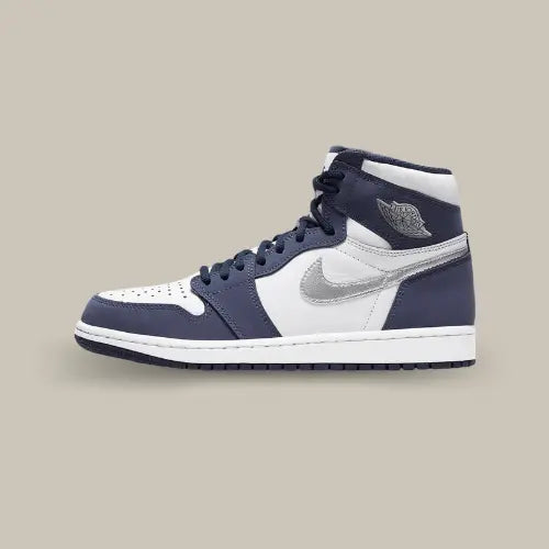 La Air Jordan 1 Retro High Midnight Navy (2020) vue de coté avec son cuir blanc, ses emiècements en suède bleu navy et son swoosh métallisé accordé aux wings.