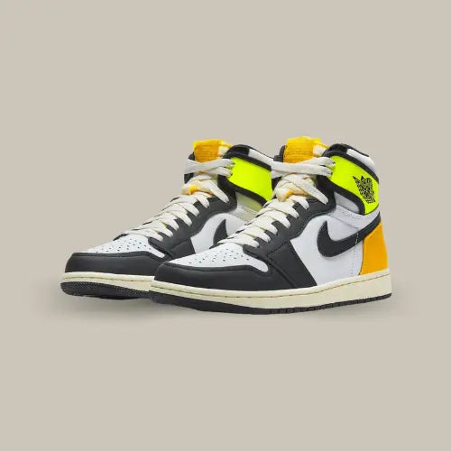 La Air Jordan 1 Retro High OG Volt University Gold possède une base en cuir blanc avec des empiècements en cuir noir sur le mudguard et les oeillets. A l'arrière de la paire, on retrouve du jaune moutarde et du orange qui vient donner un contraste au modèle.&nbsp;