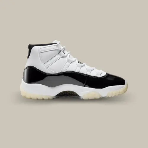 La Air Jordan 11 Retro Gratitude vue de côté avec sa base en cuir blanc et son cuir verni noir qui prend tout le long de l'empeigne.