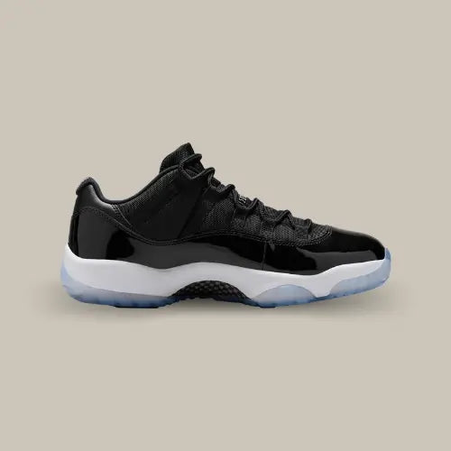 La Air Jordan 11 Retro Low Space Jam avec sa base en mesh noir, son mudguard en cuir verni noir, sa midsole blanche et son outsole icy bleu clair.
